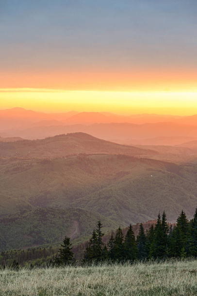 Πολύχρωμη ανατολή πάνω από τα βουνά που φαίνεται από το μεγάλο υψόμετρο .Σκηνική θέα των βουνών σιλουέτα κατά πορτοκαλί ουρανό - Φωτογραφία, εικόνα