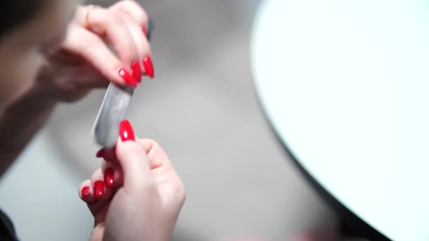 Menina corrige unhas após a manicure com um arquivo de unhas. - Filmagem, Vídeo
