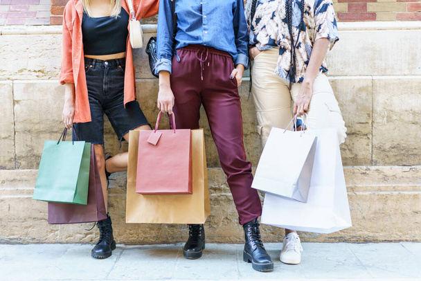 Ritaglia le donne alla moda con borse di carta in piedi sulla strada dopo lo shopping - Foto, immagini