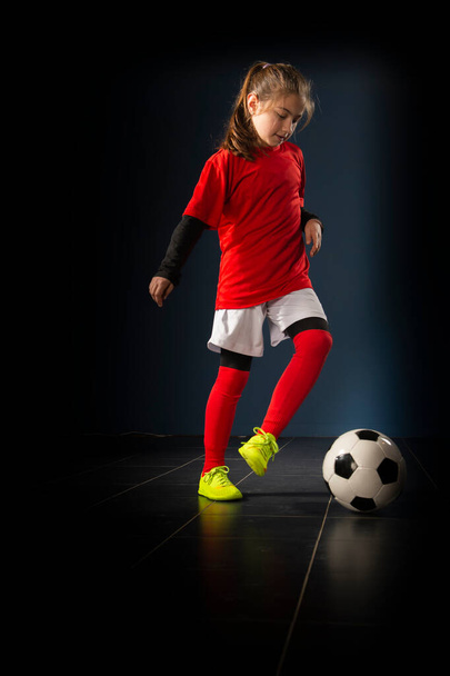 Uma menina da escola primária está jogando futebol indoor - Foto, Imagem