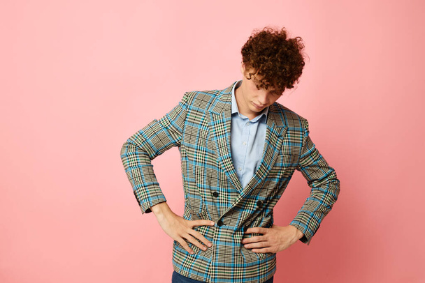 portrait of a young curly man gesturing with his hands emotions checkered jacket isolated background unaltered - Photo, Image