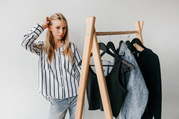 Kaunis houkutteleva nuori blondi nainen valitsemalla hänen muoti asu vaatteita vaatekauppa - Valokuva, kuva