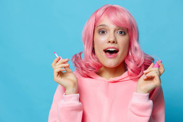 молодая женщина блеск для губ макияж розовые волосы изолированный фон - Фото, изображение