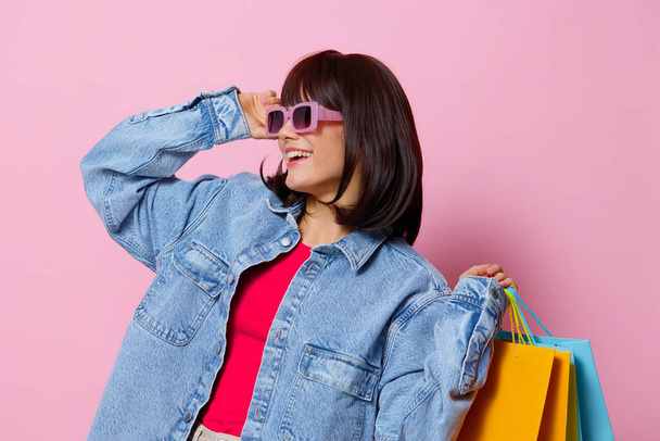 beautiful woman in denim jackets with colorful shopping bags isolated background - Photo, Image