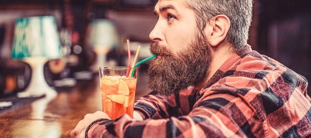 Tropical alcoholic fresh cocktail. Barman in pub or restaurant. Bearded man cocktail. Portrait man, drinking orange juice. Bearded man drink cocktails - Φωτογραφία, εικόνα