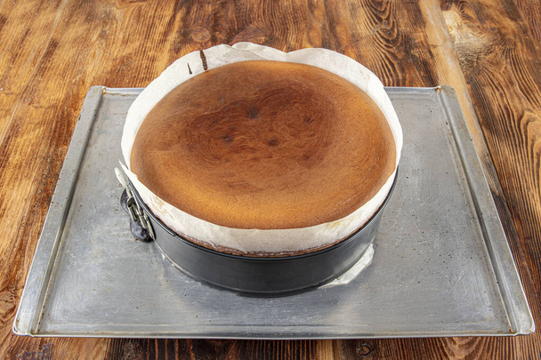 Homemade Basque спалили кремовий чізкейк, нью-йоркський стиль сирцевий пиріг в круглому випічці олова, темному фоні, селективний фокус, копіювальний простір. Тенді-десерт, домашнє приготування їжі, місцева їжа San Sebastian, Spai - Фото, зображення