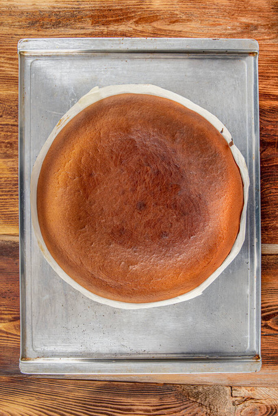 Homemade Basque спалили кремовий чізкейк, нью-йоркський стиль сирцевий пиріг в круглому випічці олова, темному фоні, селективний фокус, копіювальний простір. Тенді-десерт, домашнє приготування їжі, місцева їжа San Sebastian, Spai - Фото, зображення