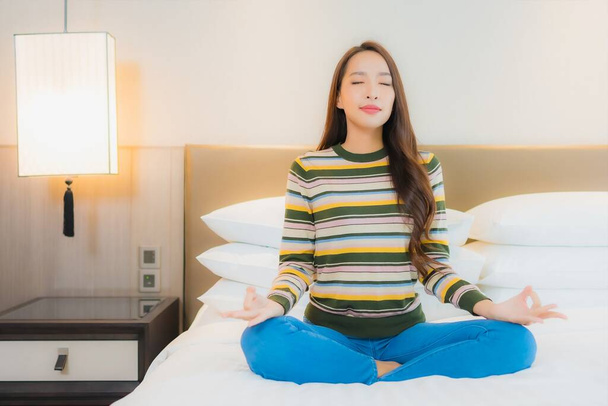肖像画美しい若いアジアの女性瞑想でベッドルームのインテリア - 写真・画像