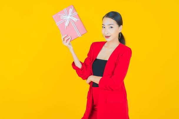 Portret piękna młoda azjatycka kobieta uśmiech z czerwonym pudełkiem na tle koloru - Zdjęcie, obraz