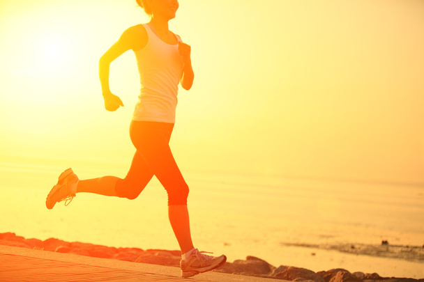 Бегущий спортсмен бежит на море. женщина фитнес-силуэт восход солнца бег трусцой тренировки оздоровительный концепт
. - Фото, изображение