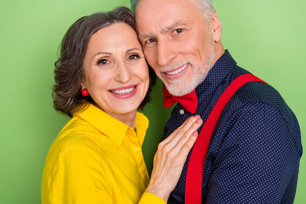Cropped close up photo of two charming positive soulmates hug look camera isolated on green color background - Fotó, kép