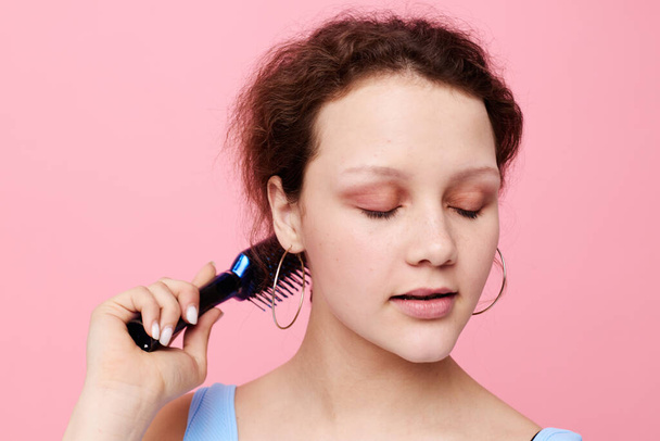 Young woman removes hair on a comb dissatisfaction isolated background unaltered - Фото, зображення