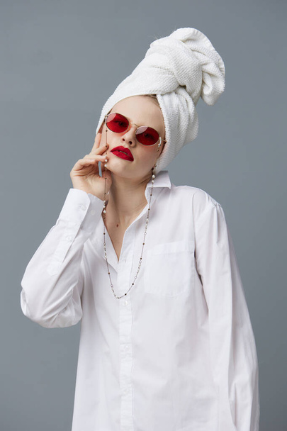 fashionable woman red sunglasses cosmetics with towel on head Gray background - Fotó, kép