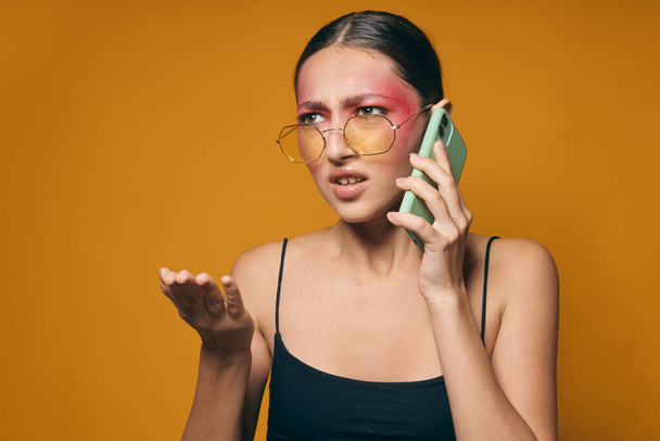 Beauty fashion female with glasses bright makeup posing black jersey talking on the phone cropped view unaltered - Photo, image
