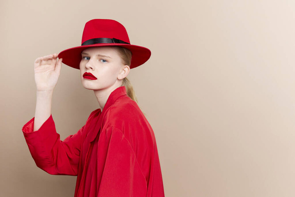portret van een vrouw rode jas en hoed rode lippen mode geïsoleerde achtergrond - Foto, afbeelding