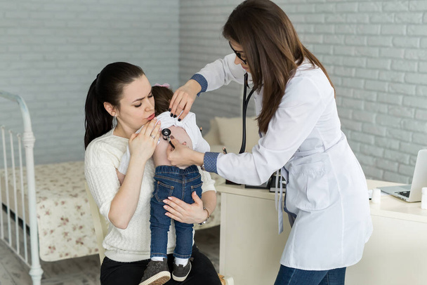 Professional general medical pediatrician doctor in white uniform gown listen lung and heart sound of child patient with stethoscope: Physician check up kid female after consult in hospital. - Foto, Imagem
