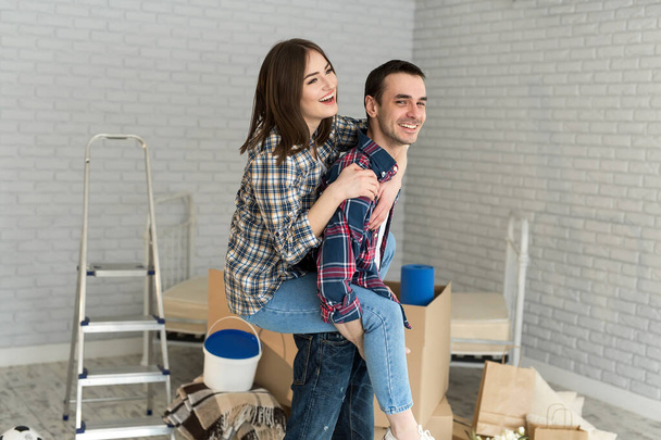 Happy couple is having fun in new house at moving day - Фото, изображение