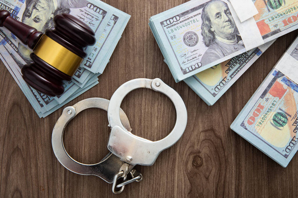 Money and handcuffs. Concept for corruption, fraud, money laundry - Photo, Image