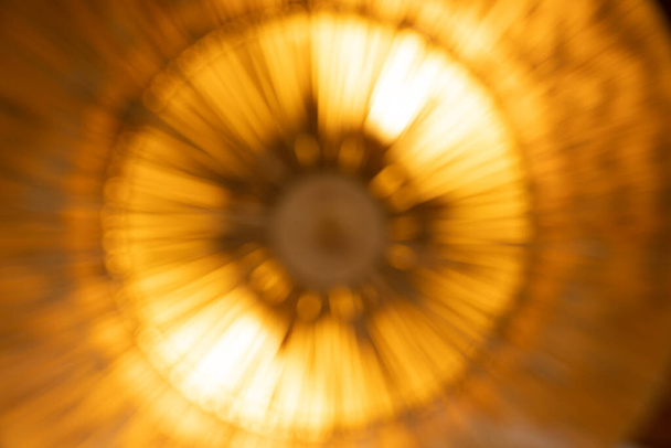 Αφηρημένη θαμπάδα πορτοκαλί φως - ακτίνα ακτίνα κίνηση και έκρηξη σαν βόμβα ή την αντίθετη άποψη μοιάζει με ηλίανθο αφηρημένο σχήμα τέχνης. - Φωτογραφία, εικόνα