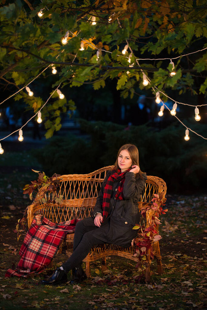Beautiful girl sitting on a bench in autumn Park. - Photo, image