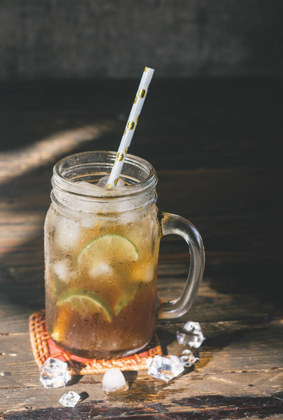 ένα παγωμένο τσάι λεμονιού στο ποτήρι με καλαμάκι - Φωτογραφία, εικόνα