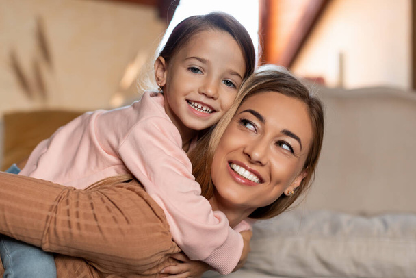 Portrait of happy young woman and daughter spending time together - Foto, imagen