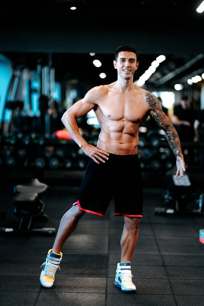 Fitness trainer posing with muscular posture at gym. Fitness healthy life concept - Фото, зображення