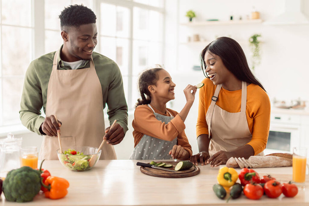 negro familia cocinar tener divertido alimentación unos a otros en cocina - Foto, Imagen