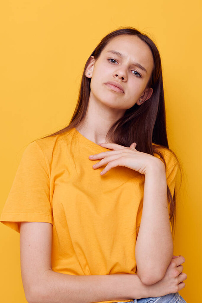 foto mooi meisje in een geel t-shirt emoties zomer stijl geïsoleerde achtergrond - Foto, afbeelding