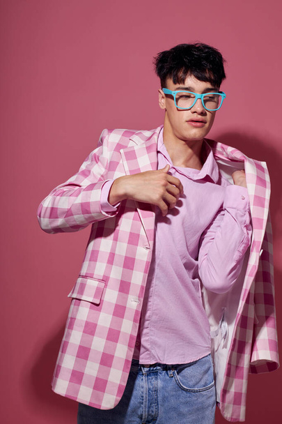 若い男ファッショナブルな眼鏡ピンクのブレザーポージングスタジオピンクの背景変更なし - 写真・画像