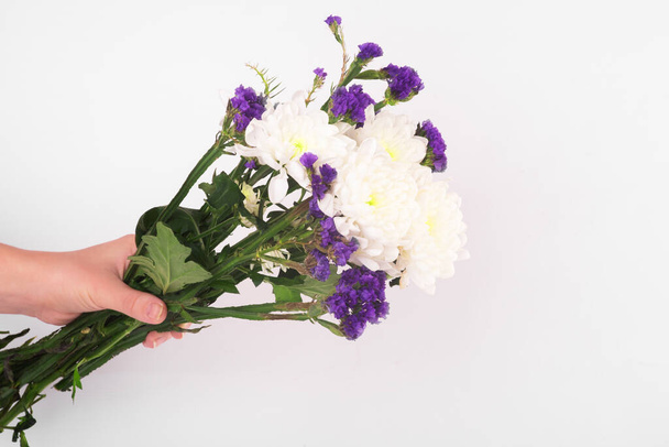 bouquet of white flowers on the hand on white background. Copy space. Top view, flat lay, frame. High resolution - Zdjęcie, obraz