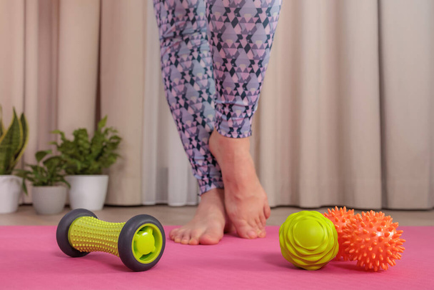 Vybavení pro myofáziální masáž nohou zblízka, dívčí nohy v pozadí - Fotografie, Obrázek
