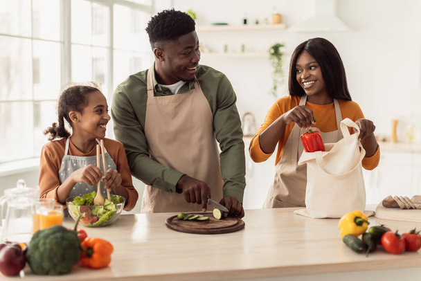 Neşeli Siyah Aile Yemekleri Modern Mutfakta Sebze Salatası Yapıyor - Fotoğraf, Görsel