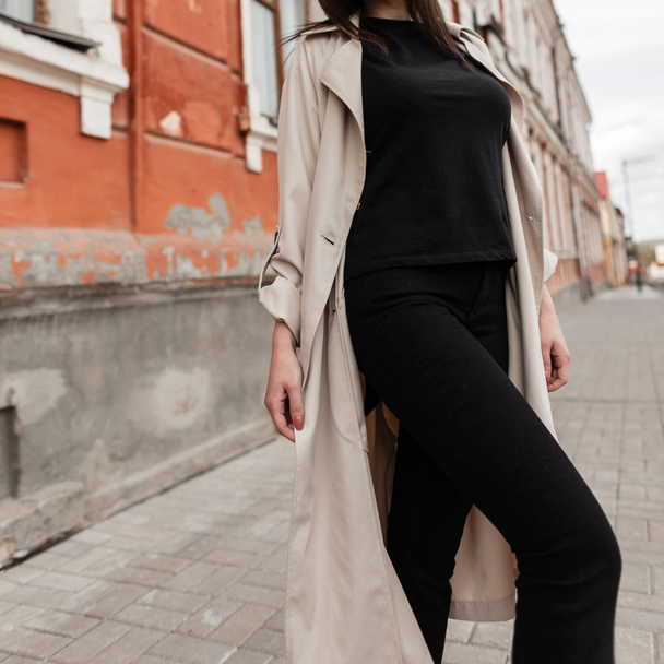 Модная случайная женщина в черной одежде с пальто ходит по улице  - Фото, изображение