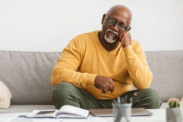 Starší afroameričan sedí na gauči doma - Fotografie, Obrázek
