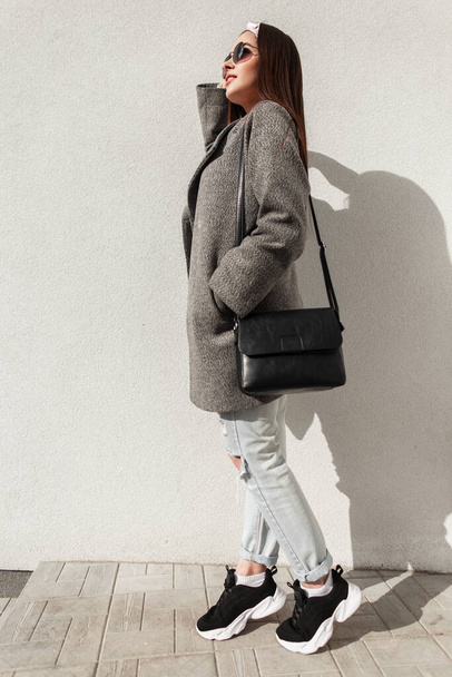 Donna urbana con bandana vintage in cappotto grigio in jeans in sneake - Foto, immagini