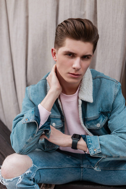 Portrait handsome European young man with trendy hairstyle in stylish denim blue jacket with white collar posing outdoors summer day. Urban good-looking guy fashion model in city. Casual street style. - Foto, Imagem