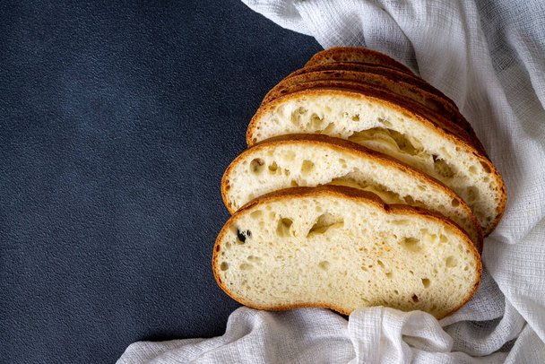 скибочки хліба без дріжджів на кефірі пшеничного борошна на синьому фоні з білою бавовняною серветкою
 - Фото, зображення