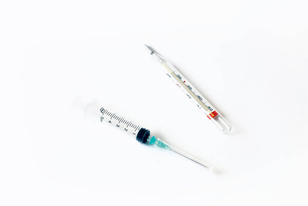 Empty syringe and thermometer closeup isolated on white background. High resolution. Injection. Vaccination. The medicine. Medical procedures and procedures. - Фото, зображення