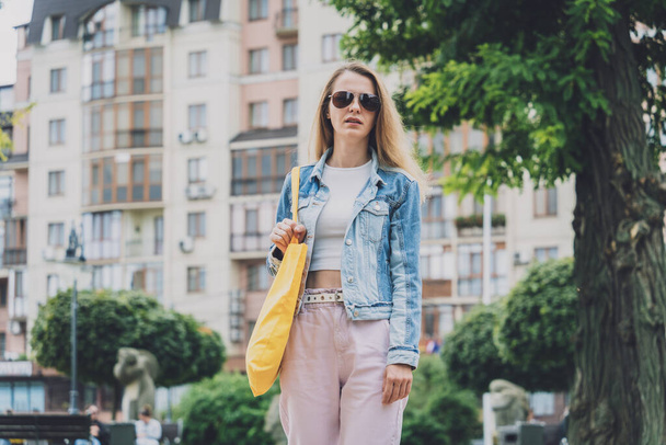 Young beautiful woman with linen eco bag on city background. - Valokuva, kuva