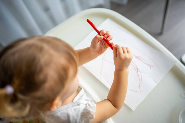 Cute little girl malowanie z filcu końcówka pióra w domu. Kreatywne gry dla dzieci. Zostań w domu. - Zdjęcie, obraz