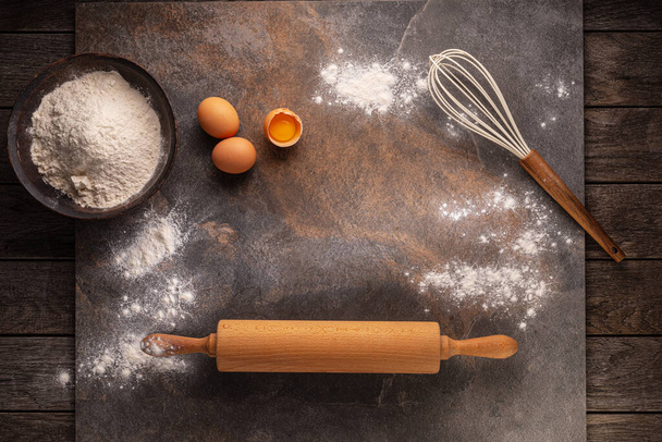 Preparation for dough cooking. Top view of board, rolling pin and flour. - Foto, Imagem