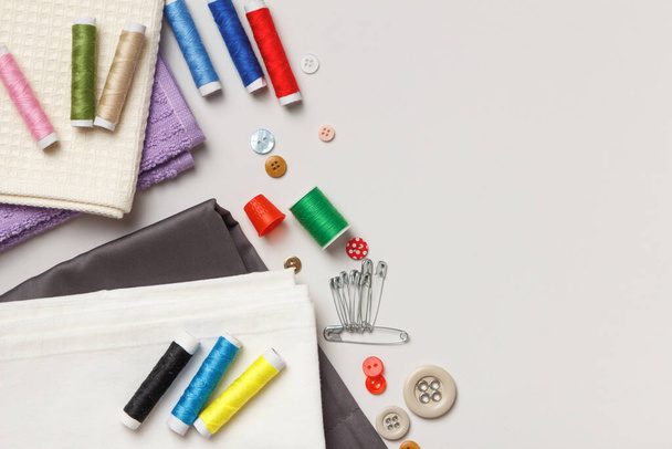 Sewing tools and accessories. Fabric and threads on a gray background. Top view flat lay copy space - Fotoğraf, Görsel