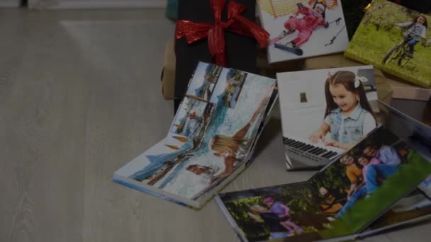 libros de fotos cerca del árbol de Año Nuevo, coloreado como un regalo para las vacaciones. - Metraje, vídeo