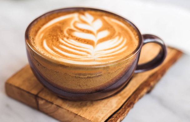 A cup of coffee latte top view with leaf shape foam - Foto, Bild