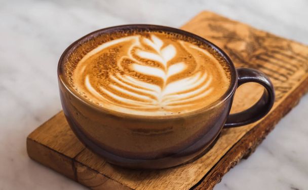 A cup of coffee latte top view with leaf shape foam - Φωτογραφία, εικόνα