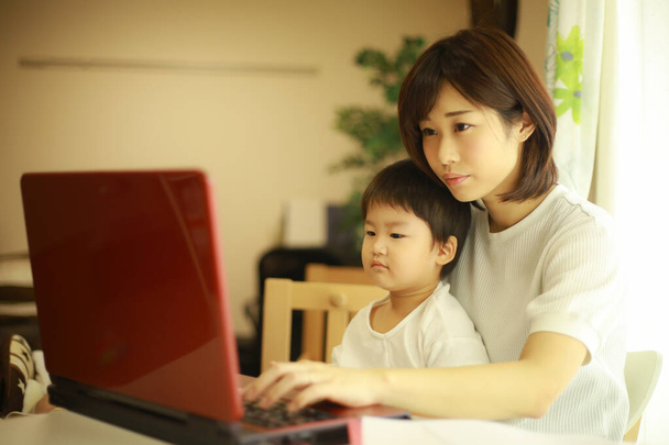 Asian young woman and her little son using laptop  - Foto, Imagem