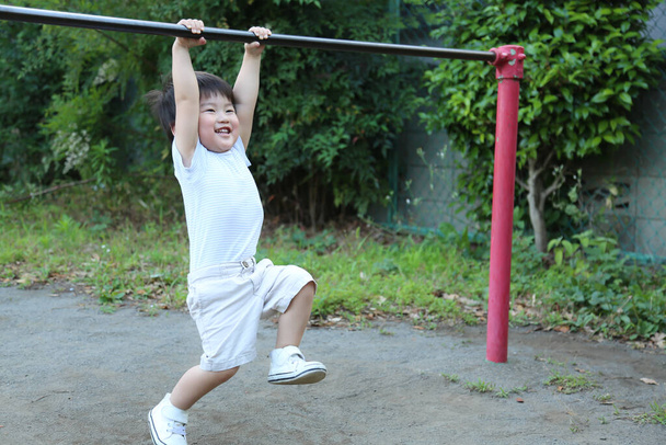幸せなアジアの少年は遊び場で時間を過ごし - 写真・画像