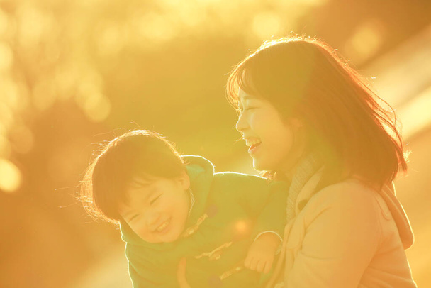 joven asiático madre con su poco hijo tener divertido en el parque   - Foto, Imagen