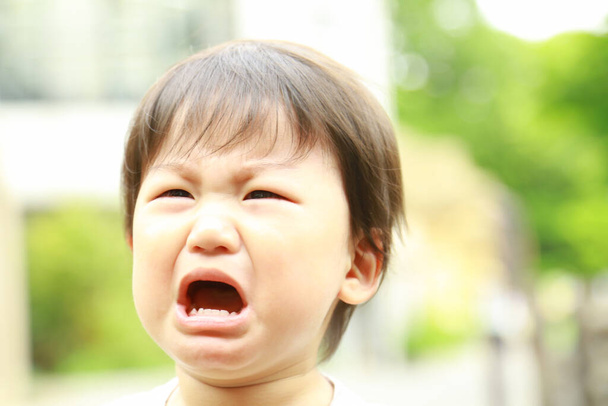 азиатский мальчик плачет в парке на открытом воздухе  - Фото, изображение